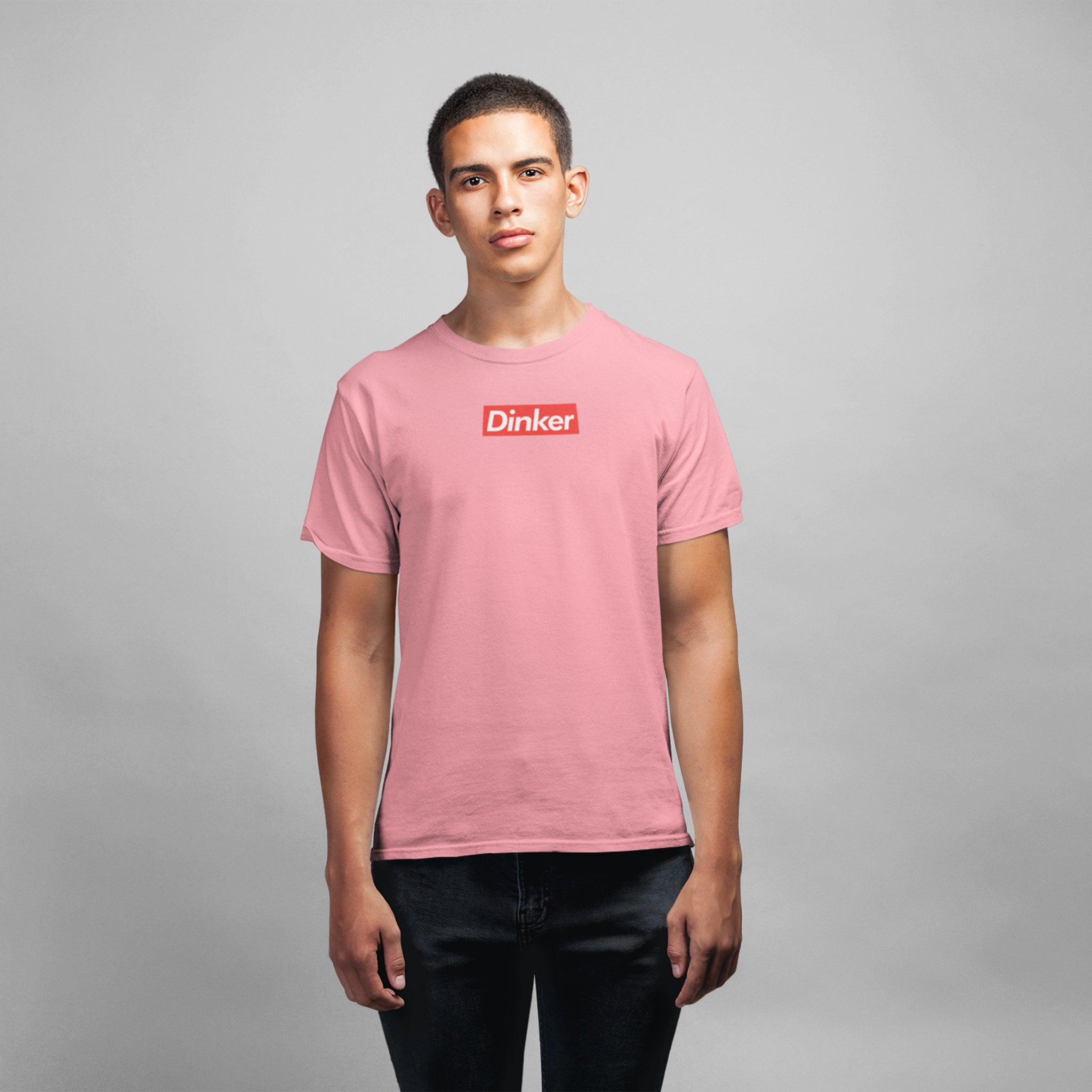 man wearing light pink dinker pickleball shirt apparel supreme inspired front view