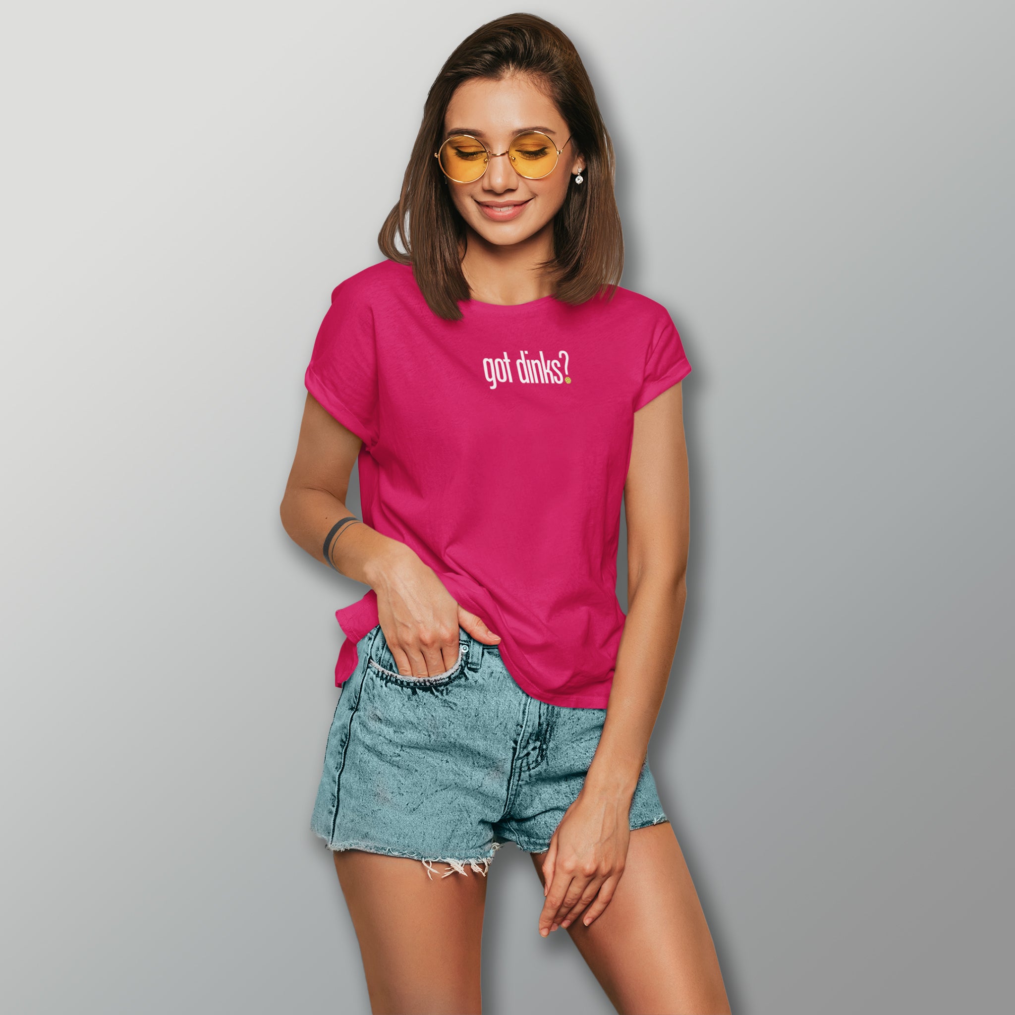 woman with sunglasses and shorts wearing magenta hot pink got dinks pickleball shirt apparel front view