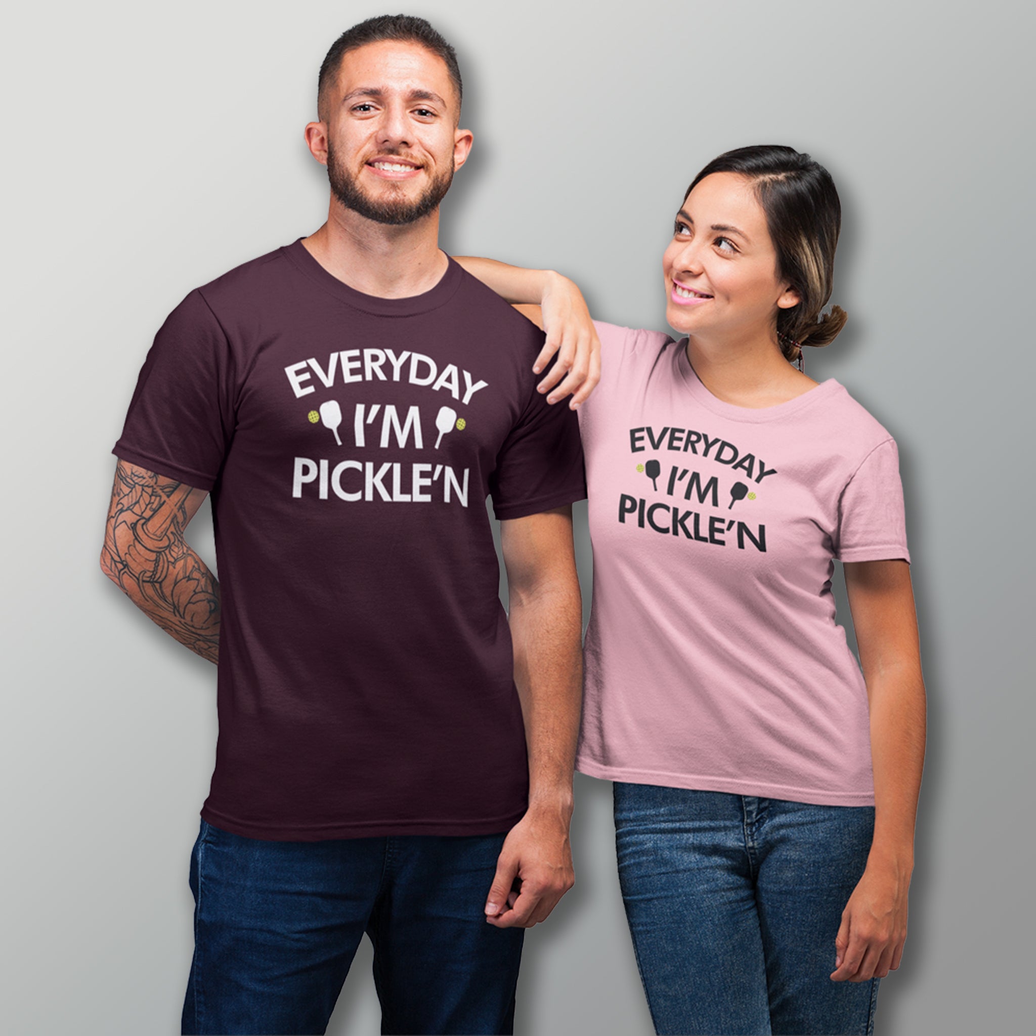 smiling couple wearing dark maroon and light pink everyday I'm pickle'n pickleball shirt apparel front view