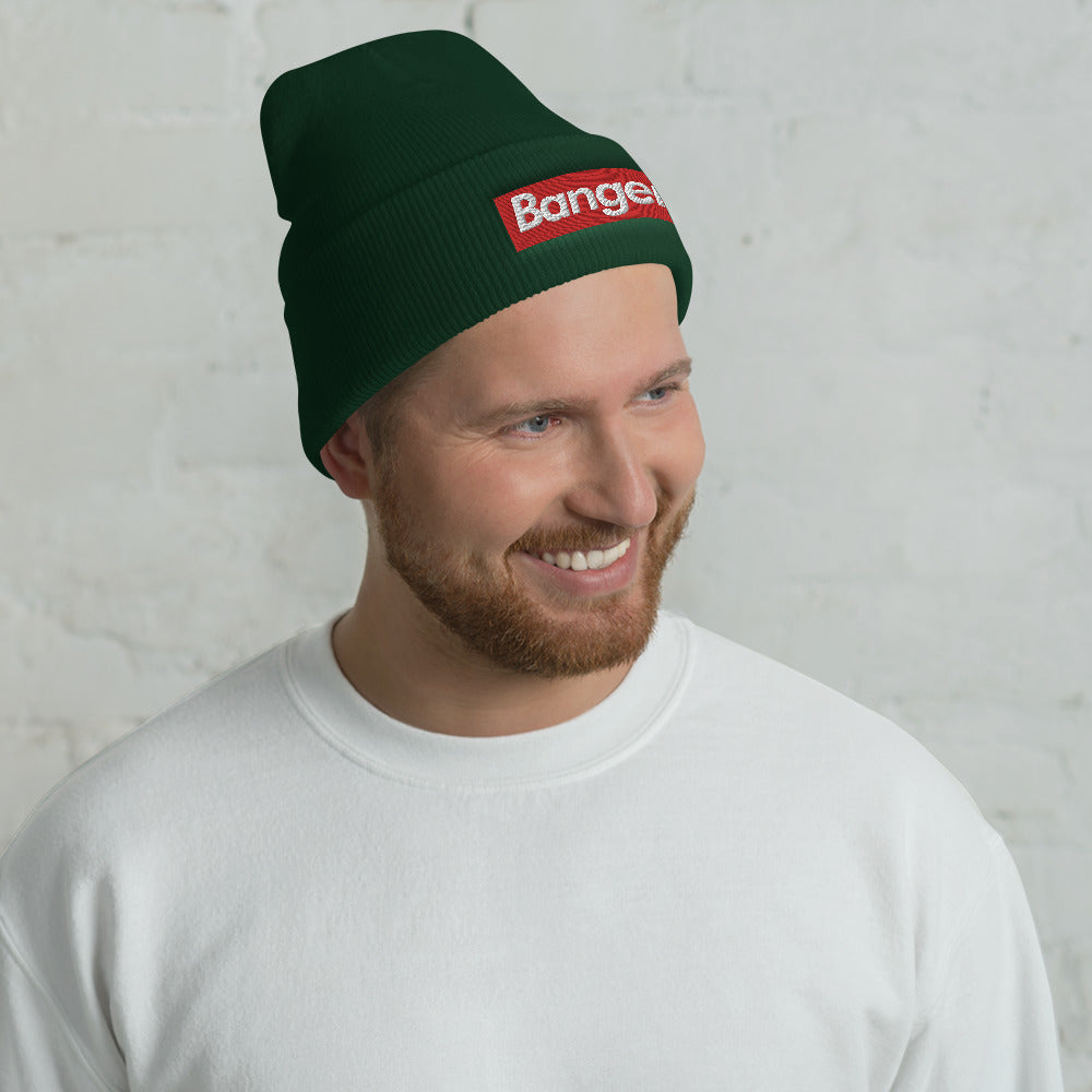 man wearing forest green pickleball beanie hat sock cap with white banger text on red background supreme style