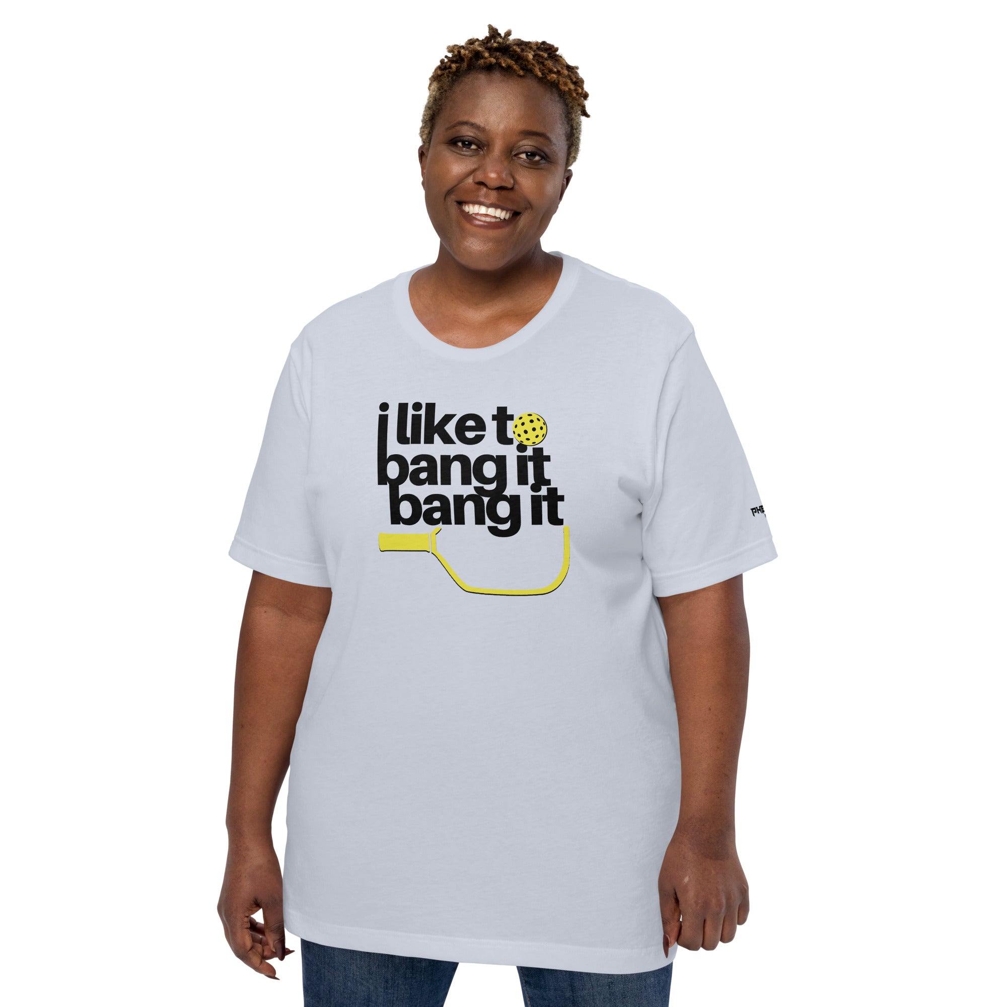 smiling plus sized woman wearing light blue i like to bang it bang it pickleball shirt athletic performance apparel front view