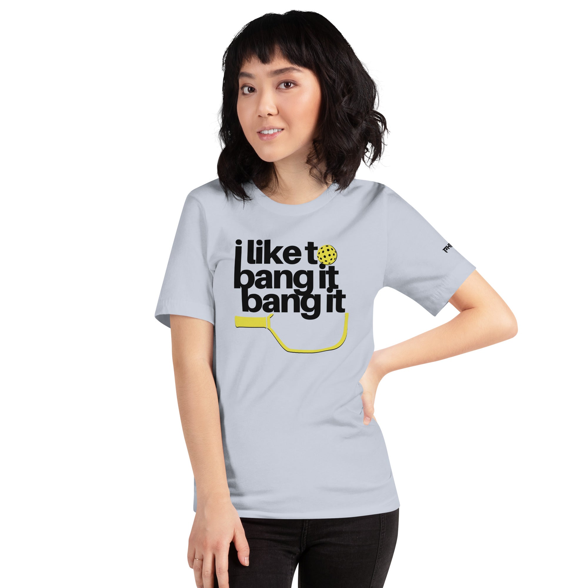 smiling petite asian woman wearing light blue i like to bang it bang it pickleball shirt athletic performance apparel front view