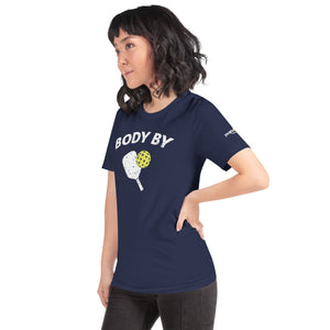 asian woman petite wearing navy blue body by pickleball shirt apparel with paddle and ball weathered look phenom logo left side view