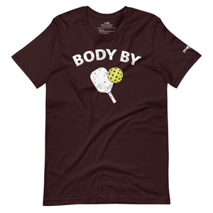 dark burgundy body by pickleball shirt apparel with paddle and ball weathered look front view