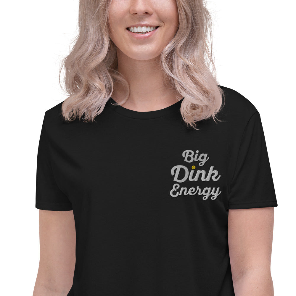 close up of blonde woman wearing black embroidered big dink energy womens crop pickleball apparel shirt